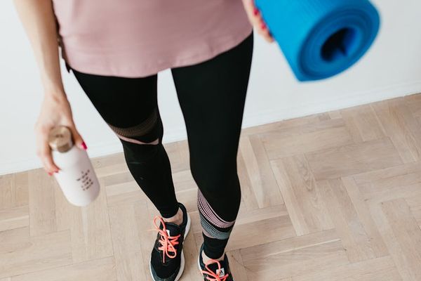 Close-up of a yoga mat and a water bottle on the floor.