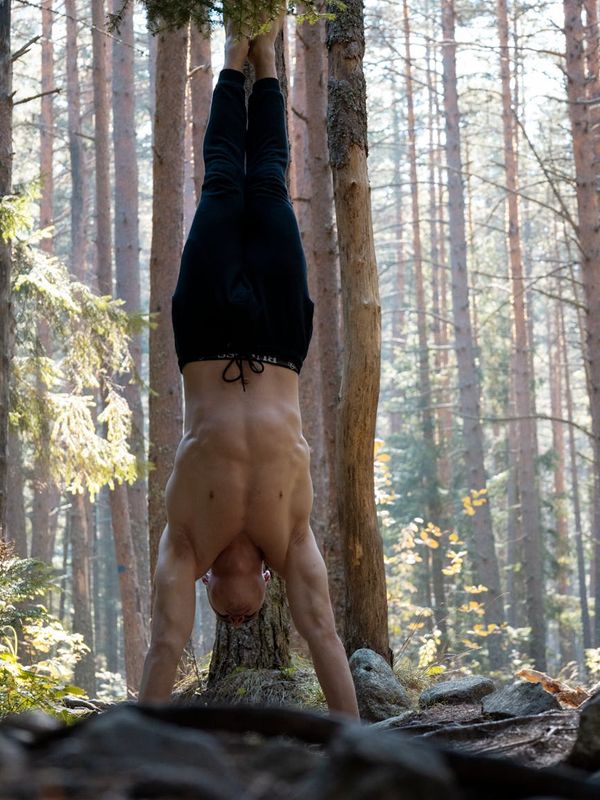 Man performing a controlled bodyweight exercise in a spacious room.